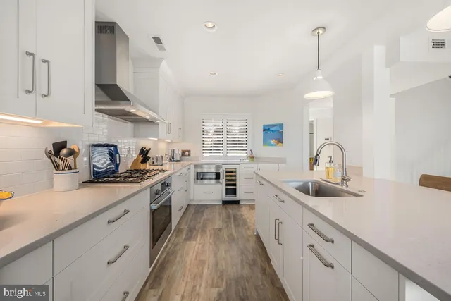 a kitchen with kitchen island granite countertop a sink stainless steel appliances and cabinets
