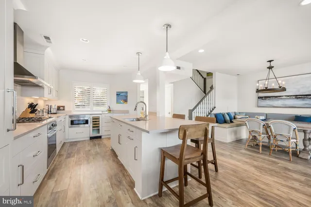 a kitchen with white cabinets and wooden floor