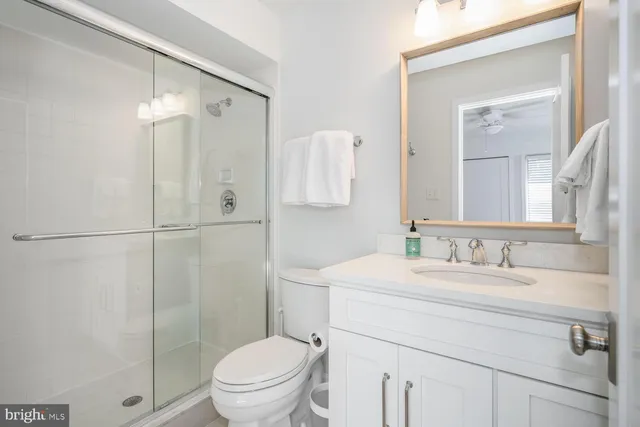 a bathroom with a sink toilet vanity and shower