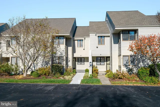 a front view of a house with a yard and trees