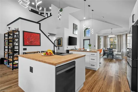 a open kitchen with stainless steel appliances kitchen island hardwood floor and a sink