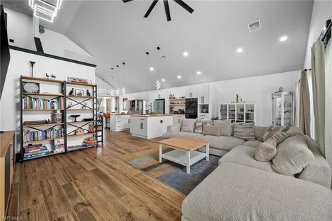 a kitchen with stainless steel appliances a white refrigerator oven a sink dishwasher and a stove with wooden floor