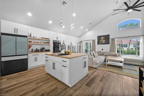a kitchen with stainless steel appliances a white cabinets and wooden floor