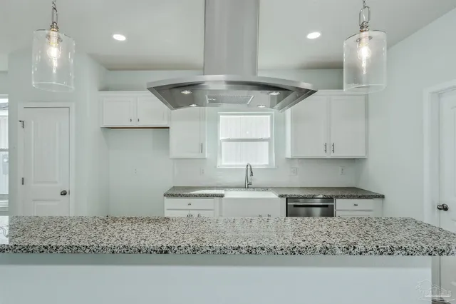 a kitchen with kitchen island granite countertop a sink window and cabinets