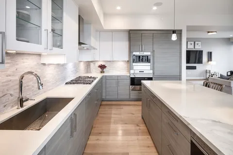 a large kitchen with stainless steel appliances granite countertop a sink and cabinets