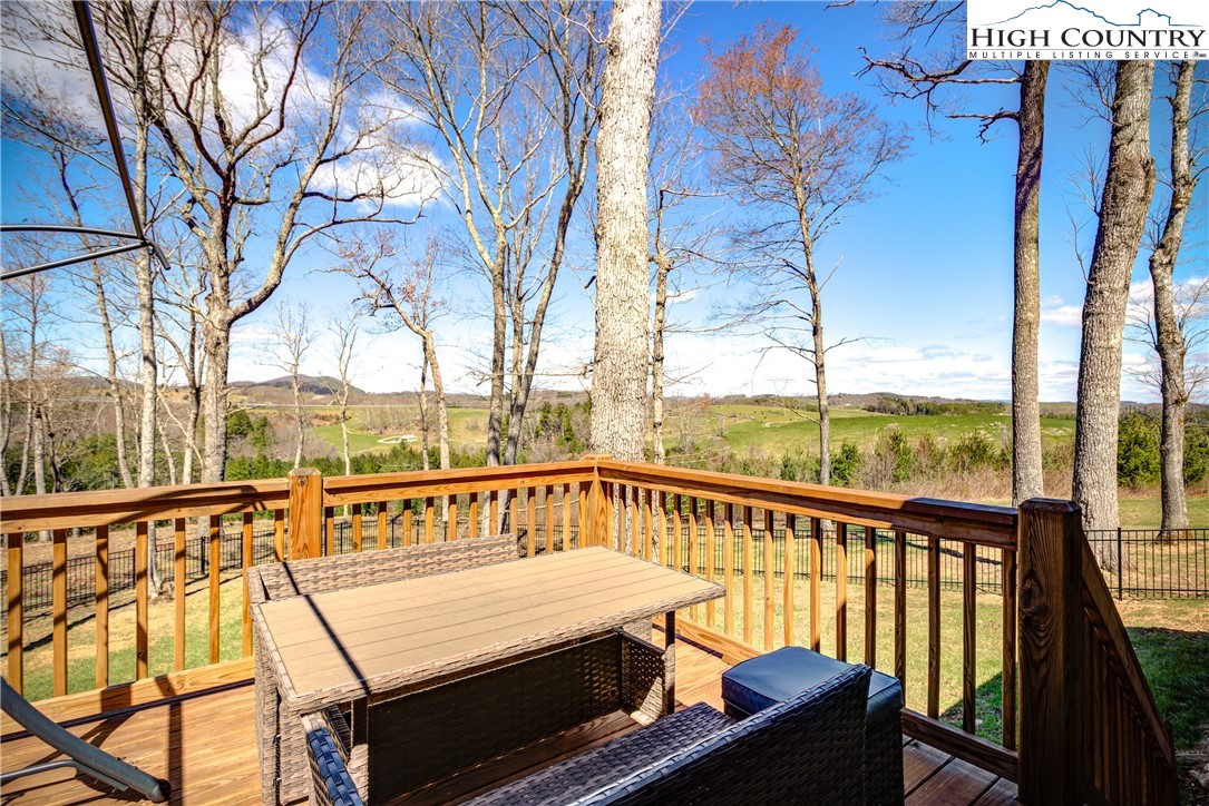 397 Turtle Ridge Road Sparta, NC 28675 - Photo 11 of 33 a view of a balcony with chairs and wooden fence