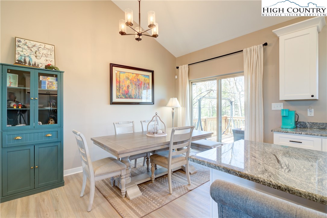 397 Turtle Ridge Road Sparta, NC 28675 - Photo 22 of 33 a dining room with wooden floor and a chandelier
