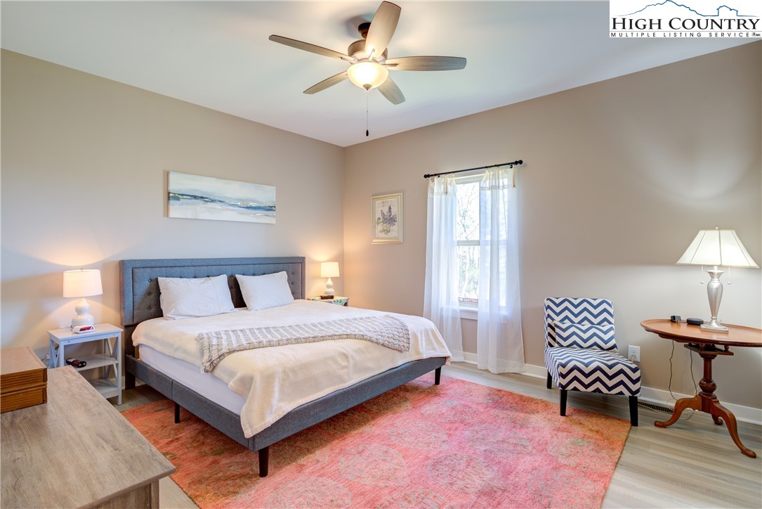 397 Turtle Ridge Road Sparta, NC 28675 - Photo 26 of 33 a bedroom with a bed couches and a chandelier