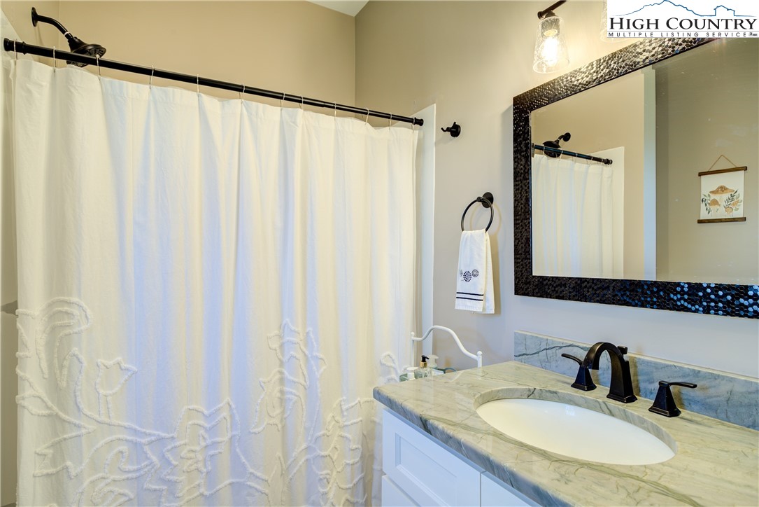 397 Turtle Ridge Road Sparta, NC 28675 - Photo 28 of 33 a bathroom with a granite countertop sink and a mirror