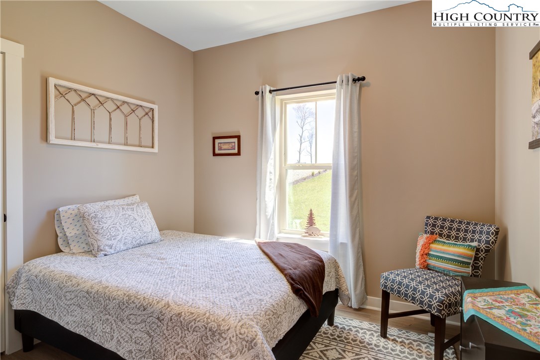 397 Turtle Ridge Road Sparta, NC 28675 - Photo 29 of 33 a bedroom with a bed and wooden floor