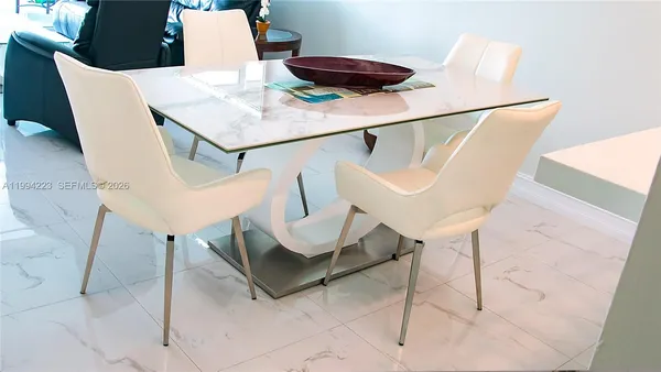 a living room with chairs and white table