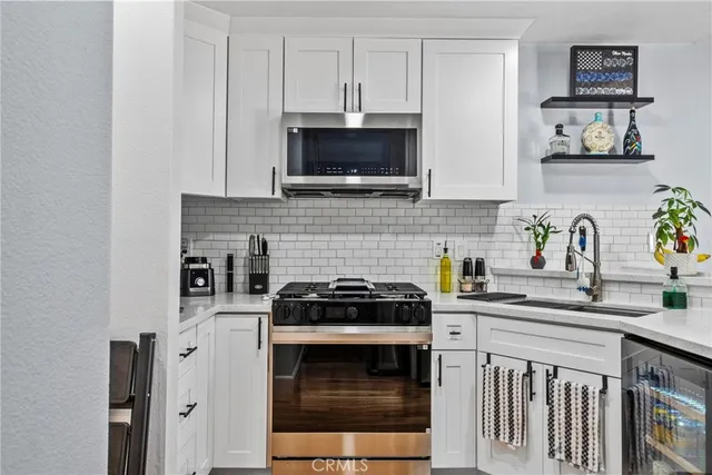 a kitchen with stainless steel appliances a stove and a sink