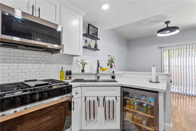 a kitchen with stainless steel appliances a sink dishwasher a stove and a microwave