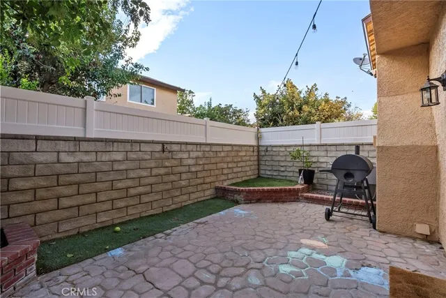 a view of a chair and table in backyard of the house