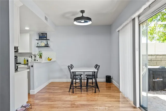 a dining room with wooden floor and a chandelier