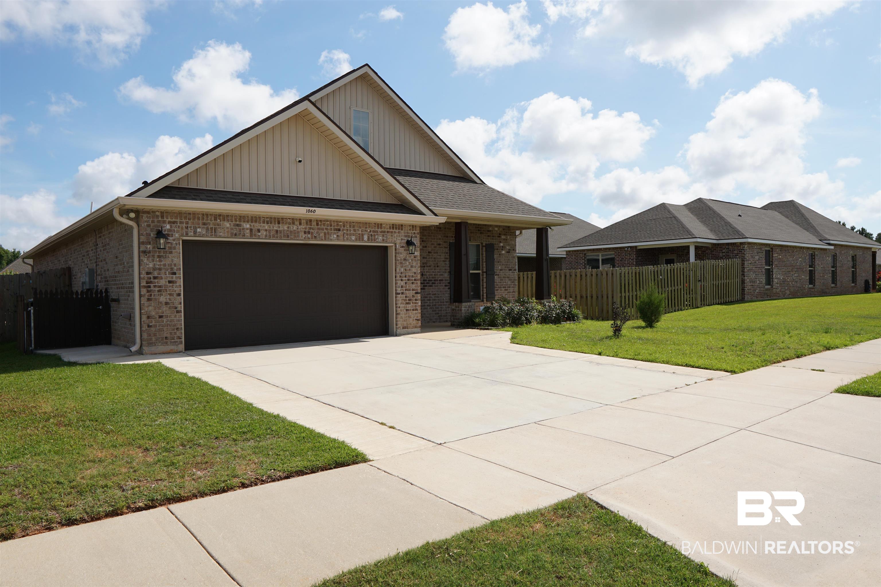 1060 Chloe Street Foley, AL 36535 - Photo 25 of 28 Front exterior featuring a brick and siding facade, a two-car garage, concrete driveway, and mature landscaping