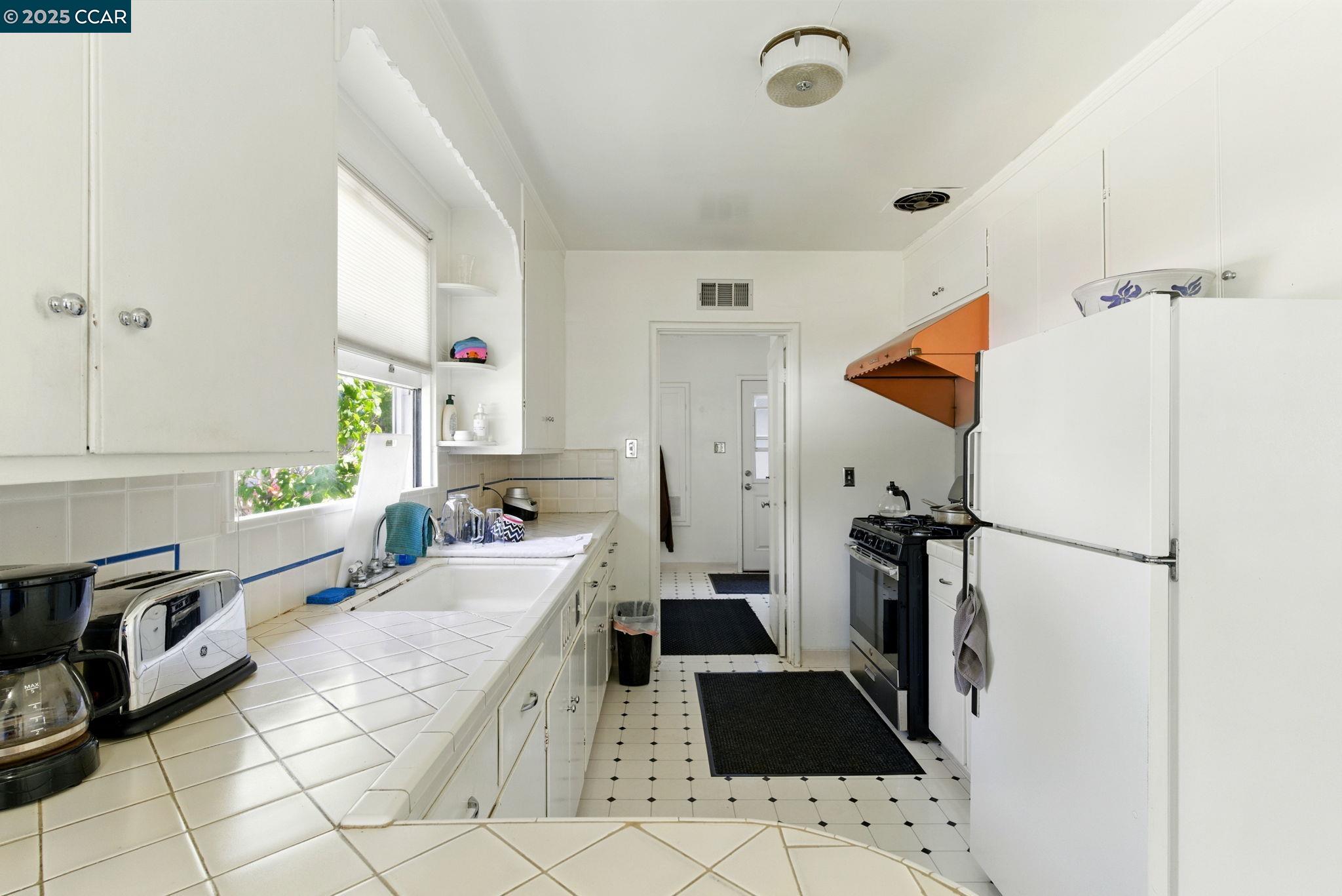 500 Wano Street Martinez, CA 94553 - Photo 15 of 30 a large white kitchen with a stove a refrigerator and a sink