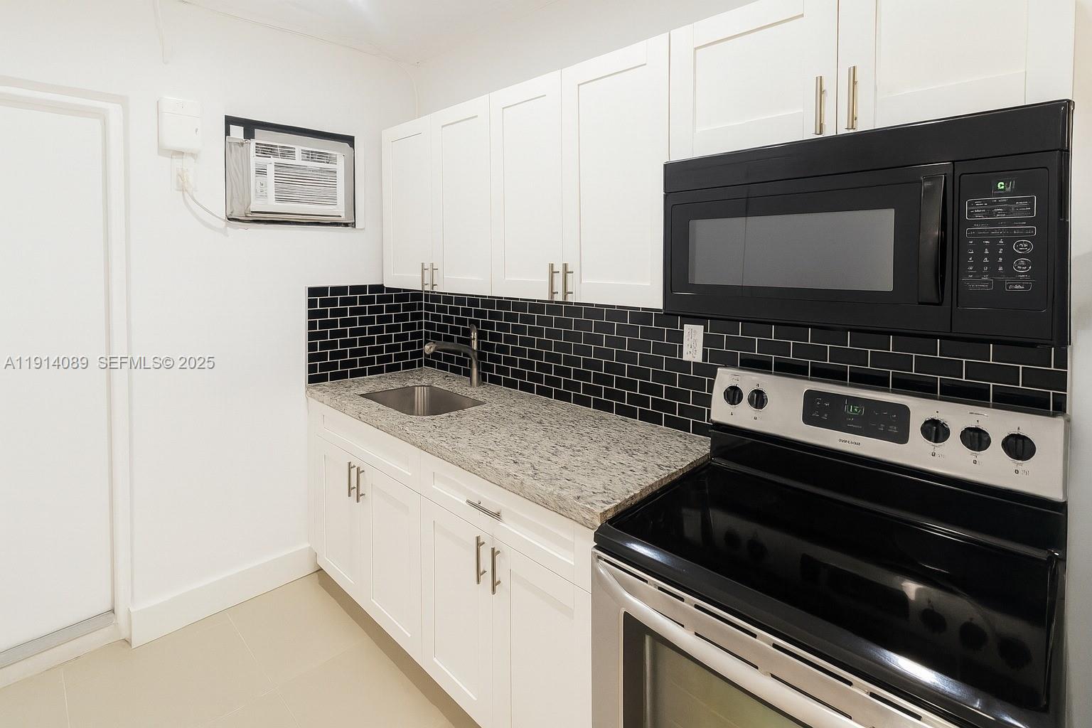 5807 Southwest 25th Street, Unit 9 West Park, FL 33023 - Photo 3 of 7 a close view of a stove a microwave and cabinets