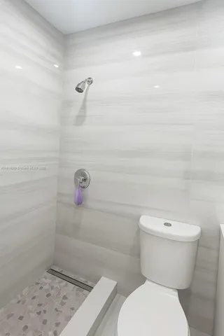a bathroom with a toilet and a shower