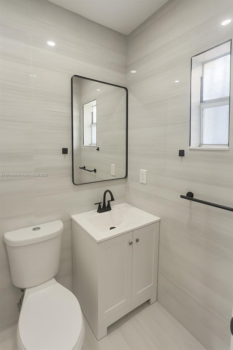5807 Southwest 25th Street, Unit 9 West Park, FL 33023 - Photo 5 of 7 a bathroom with a toilet sink and mirror