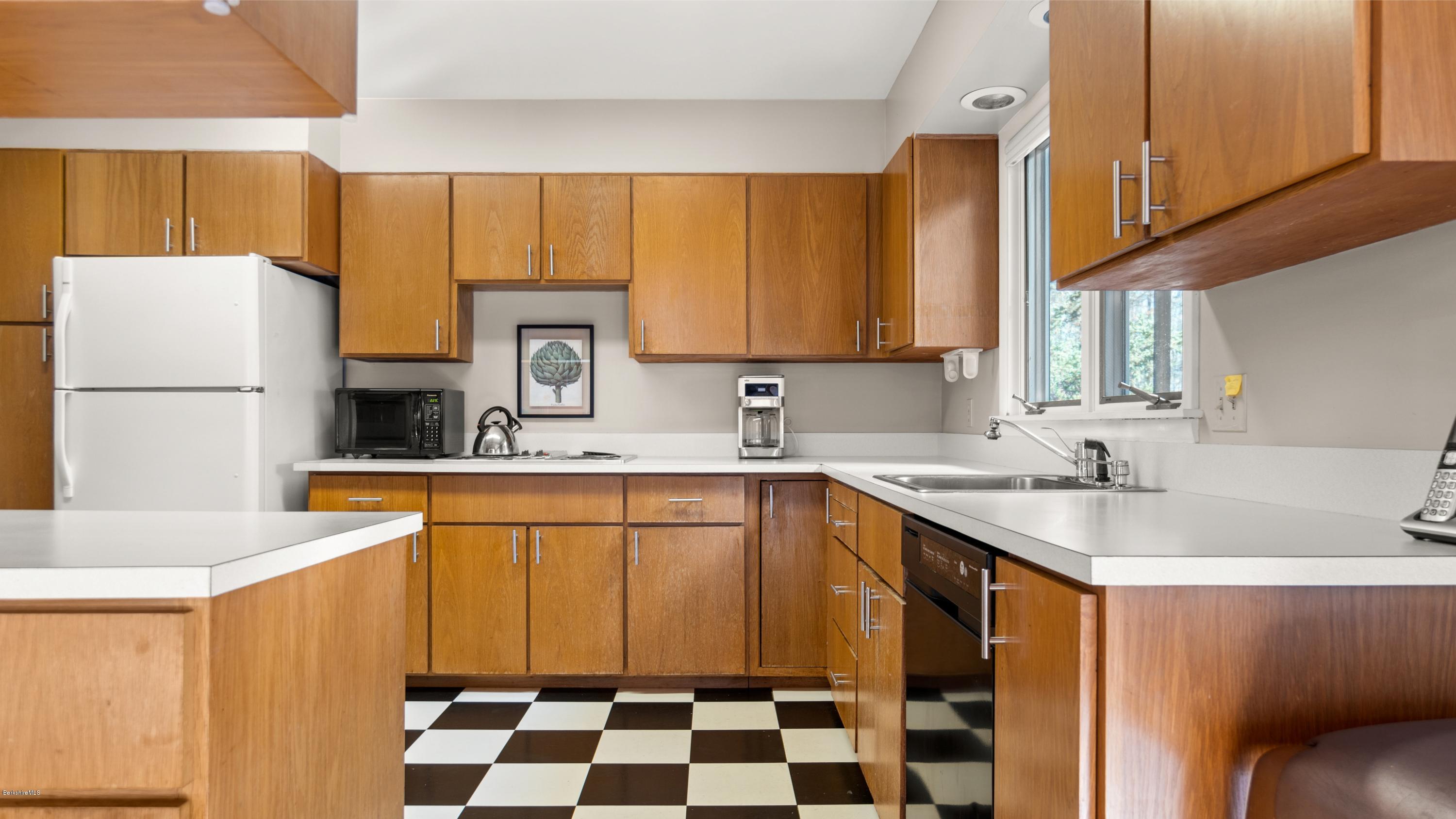 23 Interlaken Road Stockbridge, MA 01266 - Photo 9 of 26 a kitchen with a sink a refrigerator a stove a microwave and cabinets