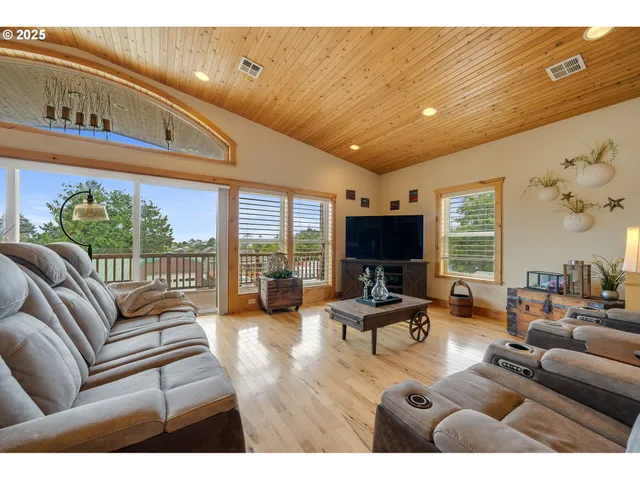 a living room with furniture large window and flat screen tv