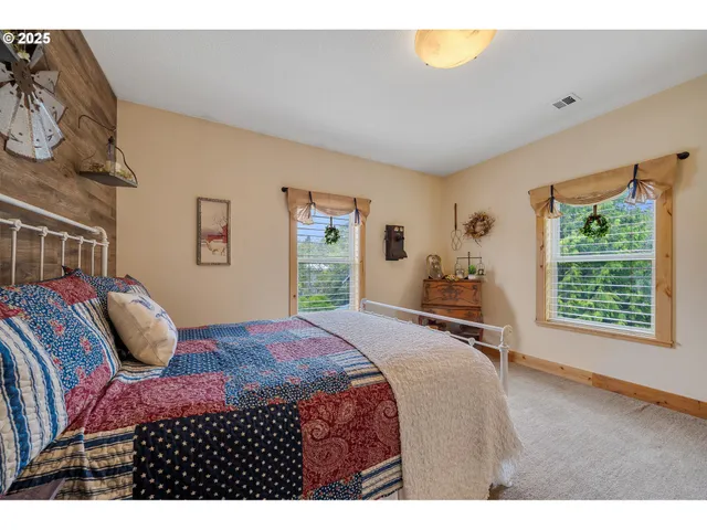 a bedroom with a bed and a dresser next to a window