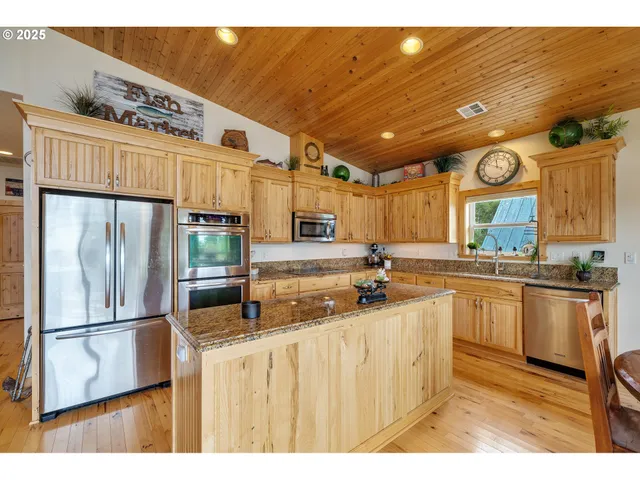 a kitchen with stainless steel appliances granite countertop a sink a stove and refrigerator