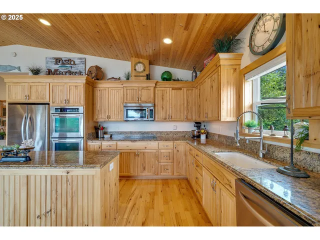 a kitchen with stainless steel appliances granite countertop a sink and wooden cabinets