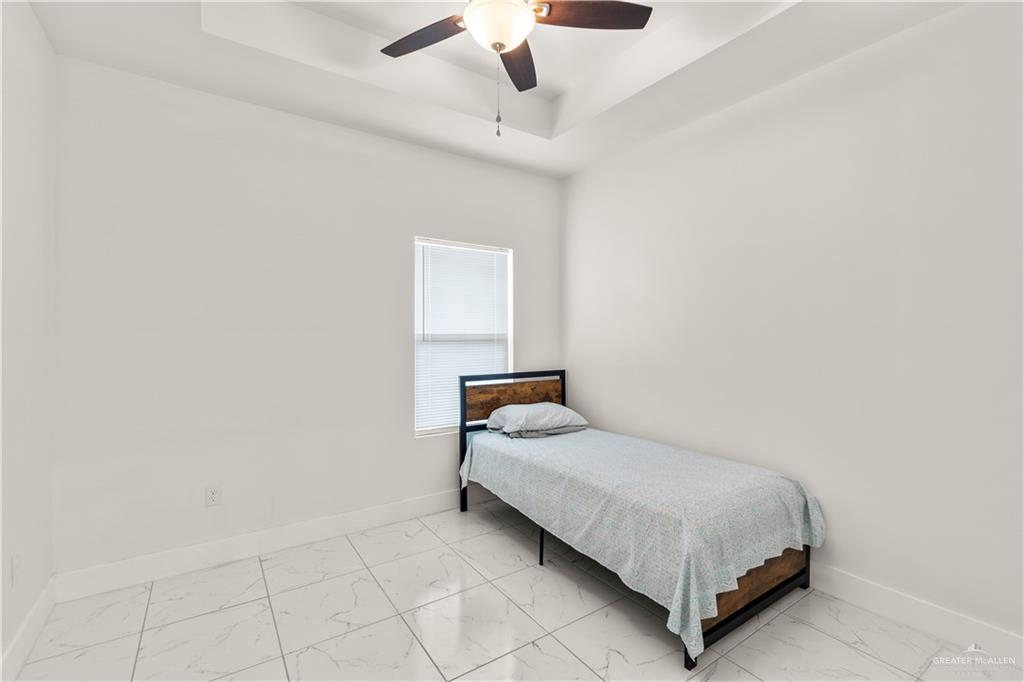 23232 Val Verde Road Edcouch, TX 78538 - Photo 11 of 19 a bedroom with a bed and a chandelier fan