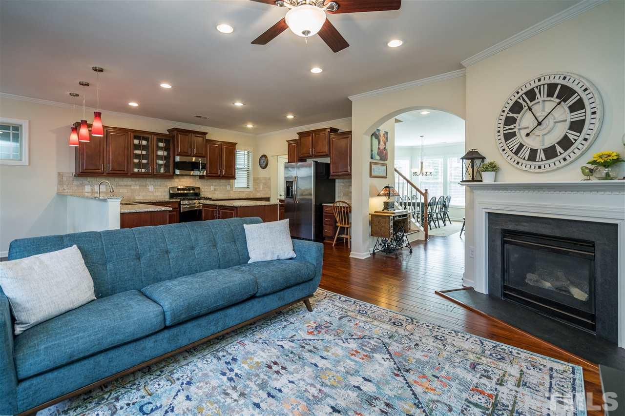 5630 Wade Park Boulevard Raleigh, NC 27607 - Photo 13 of 30 Living room features a gas fireplace, windows on both walls, hardwoods, fan, and recessed lighting!