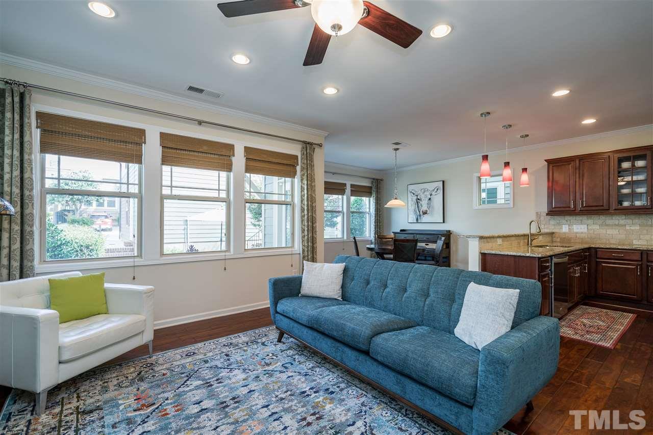 5630 Wade Park Boulevard Raleigh, NC 27607 - Photo 14 of 30 Living room features a gas fireplace, windows on both walls, hardwoods, fan, and recessed lighting!