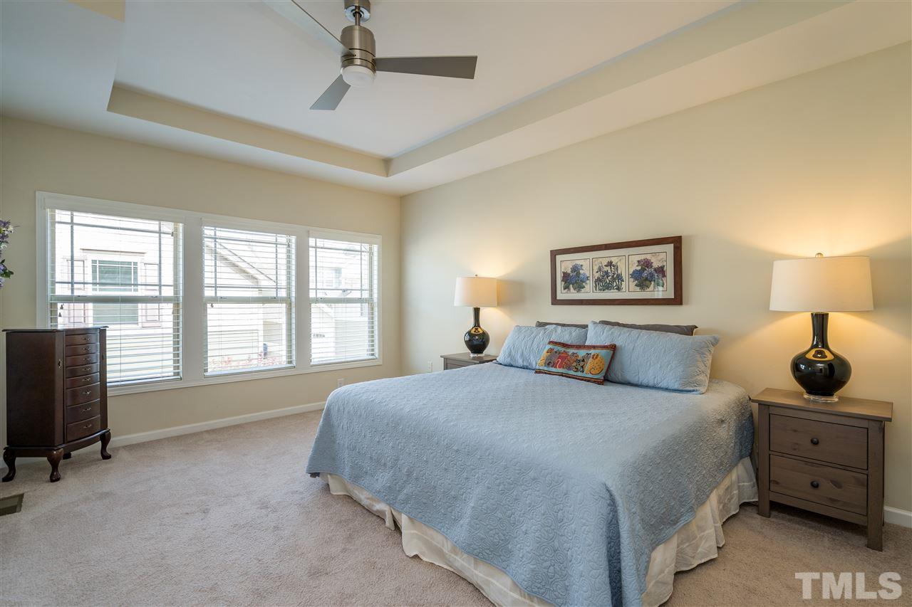 5630 Wade Park Boulevard Raleigh, NC 27607 - Photo 17 of 30 Owner's suite features a tray ceiling, ceiling fan, WIC with wooden shelving, and en suite spa-like bathroom!