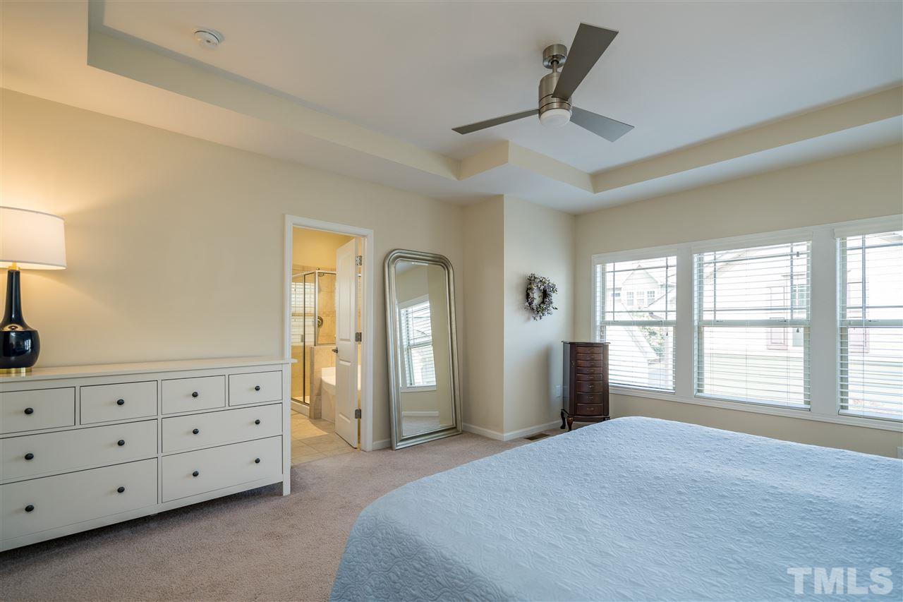 5630 Wade Park Boulevard Raleigh, NC 27607 - Photo 18 of 30 Owner's suite features a tray ceiling, ceiling fan, WIC with wooden shelving, and en suite spa-like bathroom!