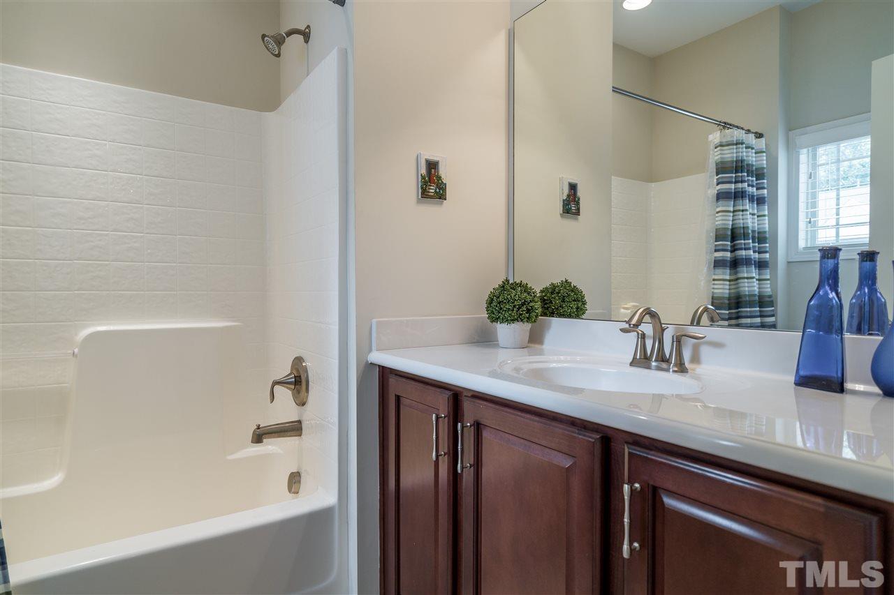 5630 Wade Park Boulevard Raleigh, NC 27607 - Photo 22 of 30 Upstairs shared bathroom for two secondary bedrooms. Ceramic tile, easy to clean shower and coordinating cabinets make this bath stylish and convenient!