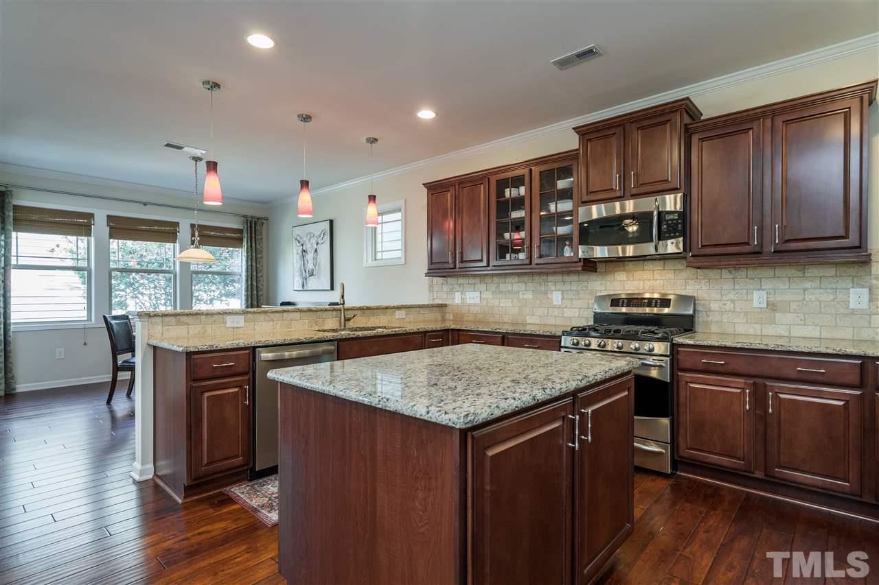 5630 Wade Park Boulevard Raleigh, NC 27607 - Photo 8 of 30 This kitchen has it all! Open concept, island, working desk, granite, subway tile, stainless appliances, included refrigerator, glass front cabinet and recessed can lighting!