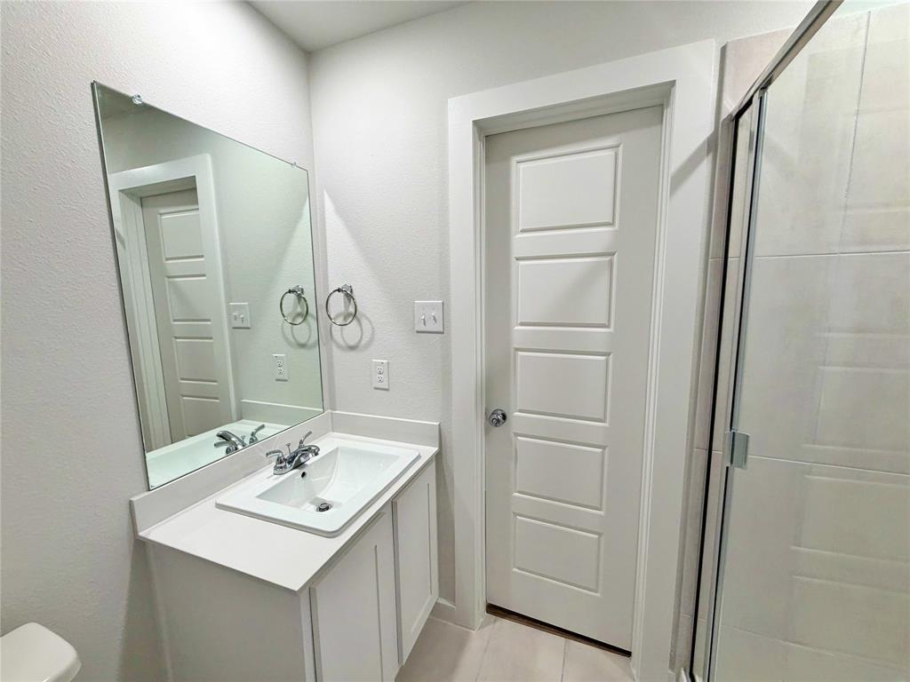 2203 Heatwave Lane Princeton, TX 75407 - Photo 17 of 32 a bathroom with a sink a toilet and vanity