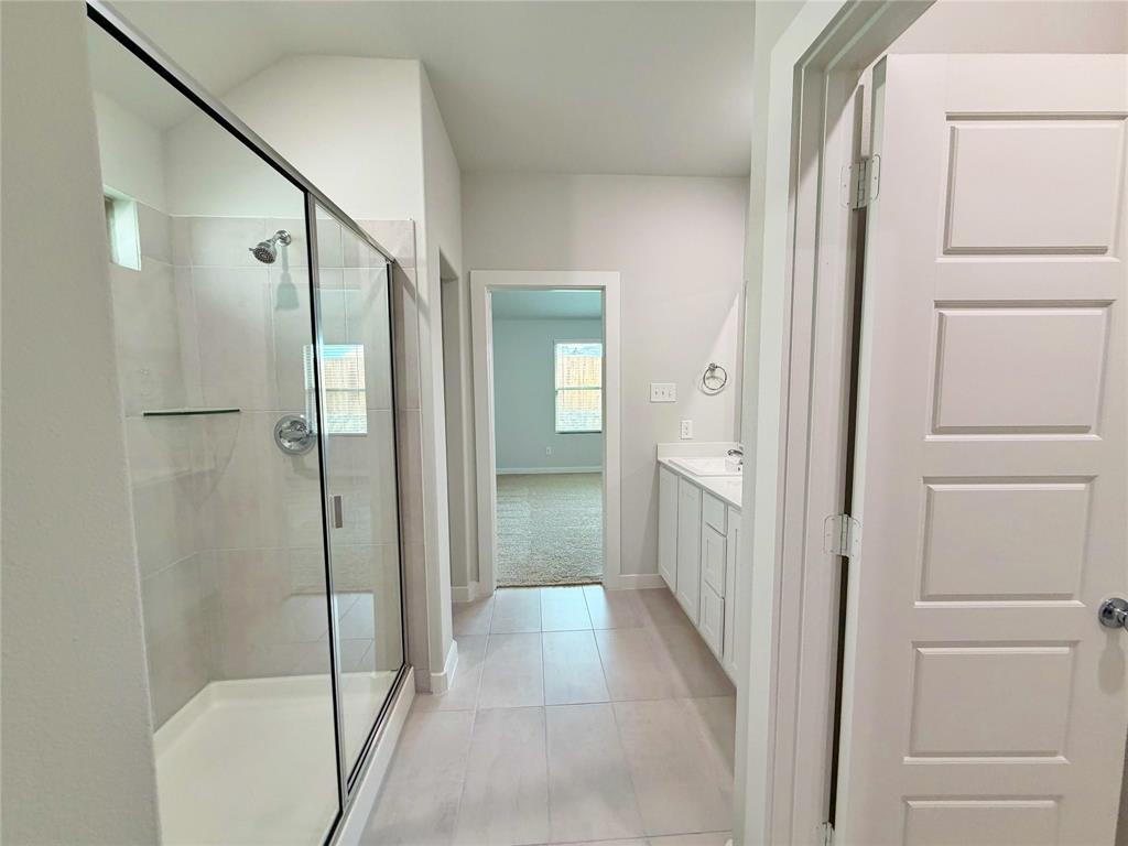 2203 Heatwave Lane Princeton, TX 75407 - Photo 19 of 32 a bathroom with a glass shower door and a toilet