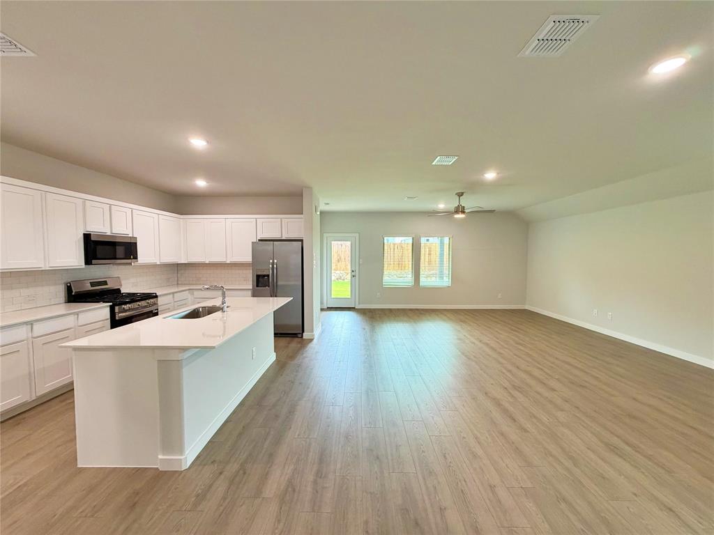2203 Heatwave Lane Princeton, TX 75407 - Photo 9 of 32 a large kitchen with stainless steel appliances granite countertop a large center island a sink dishwasher a refrigerator with wooden floor and cabinets