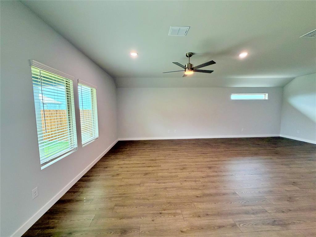 2203 Heatwave Lane Princeton, TX 75407 - Photo 10 of 32 wooden floor in an empty room with a window