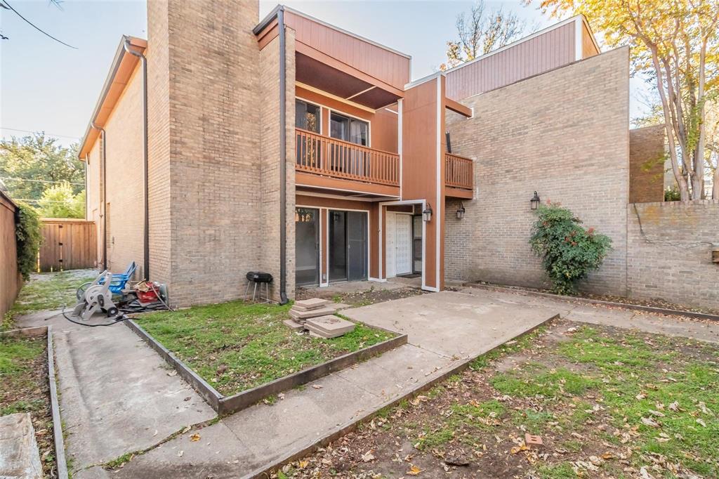 4930 Thunder Road Dallas, TX 75244 - Photo 3 of 23 Brick exterior with a second-story wood-finish balcony, ground-level patio door, and concrete patio area