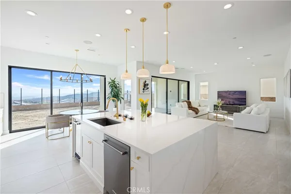a large kitchen with kitchen island a large counter top appliances and a view of living room