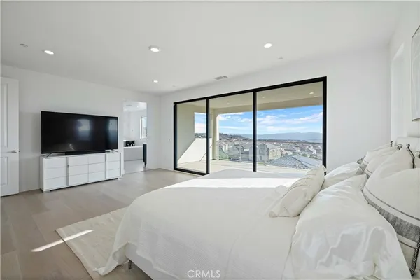 a bedroom with a large bed and a flat screen tv