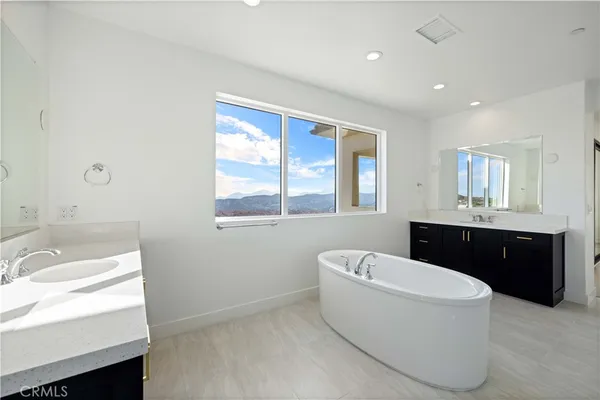 a spacious bathroom with a bathtub sink and mirror