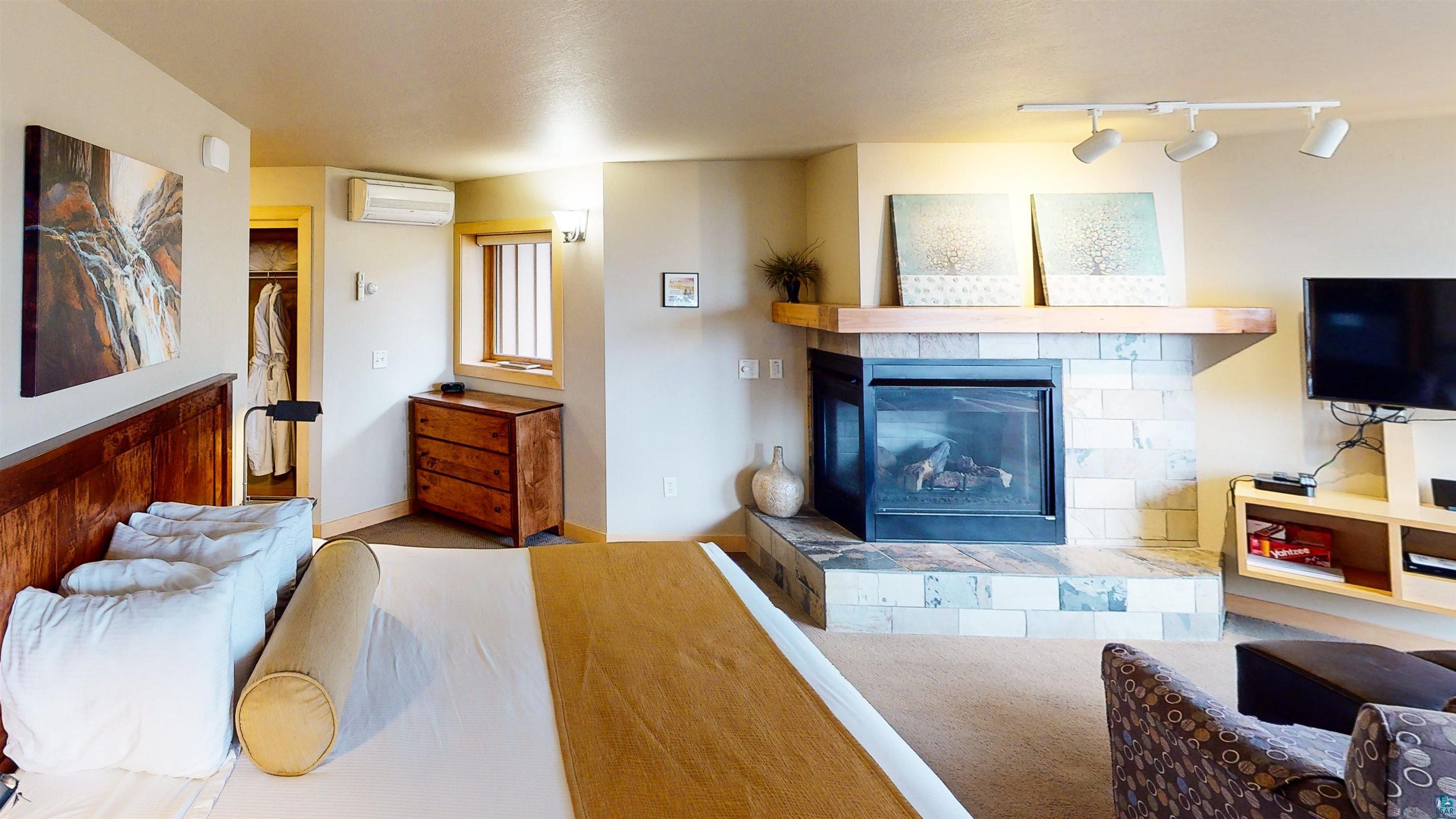 40 Surfside Drive, Unit 5D Tofte, MN 55615 - Photo 8 of 37 Interior space featuring a stone-clad fireplace with a wood mantle, track lighting, and carpeted flooring