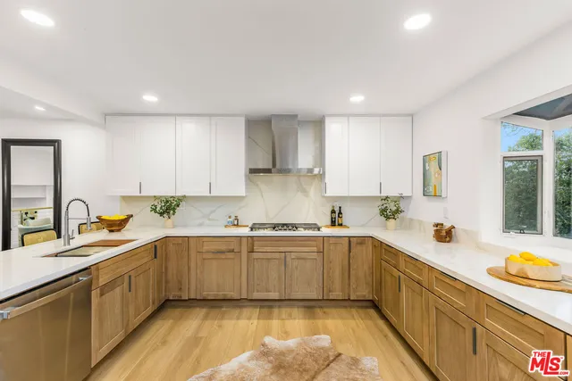 a kitchen with a sink a window cabinets and stainless steel appliances