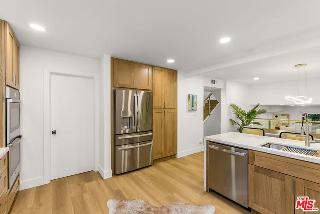 a kitchen with granite countertop a refrigerator and a sink