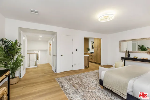 a spacious bedroom with a bed and wooden floor