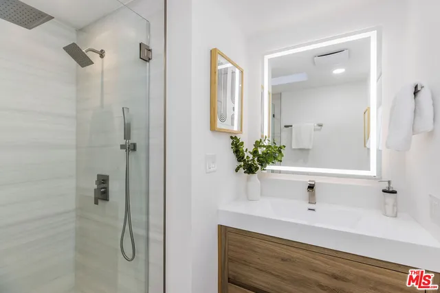 a bathroom with a bathtub shower sink and mirror