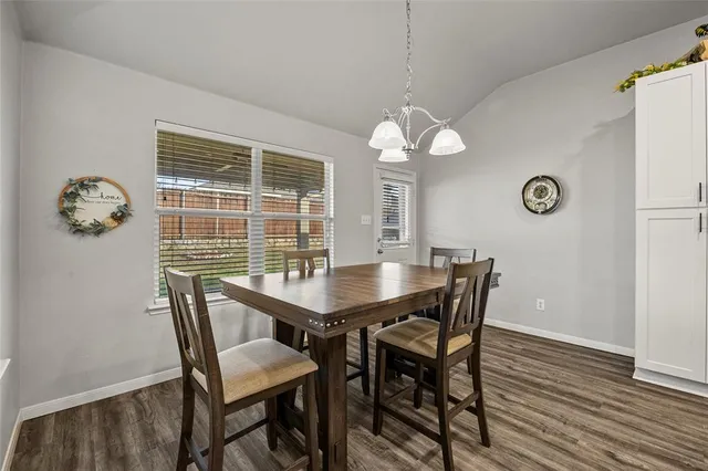 a view of a dining room with furniture wooden floor and chandelier